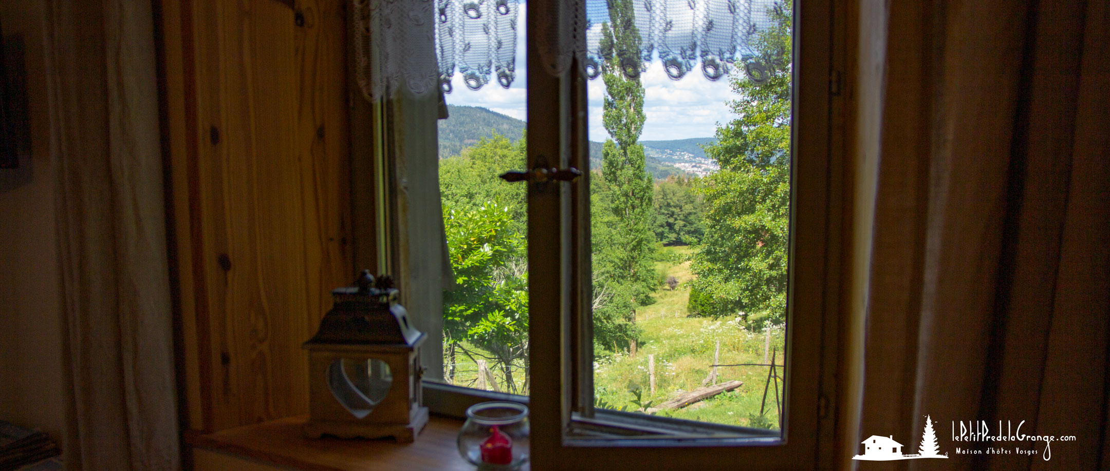 Fenêtre du salon avec vue le pré et la vallée